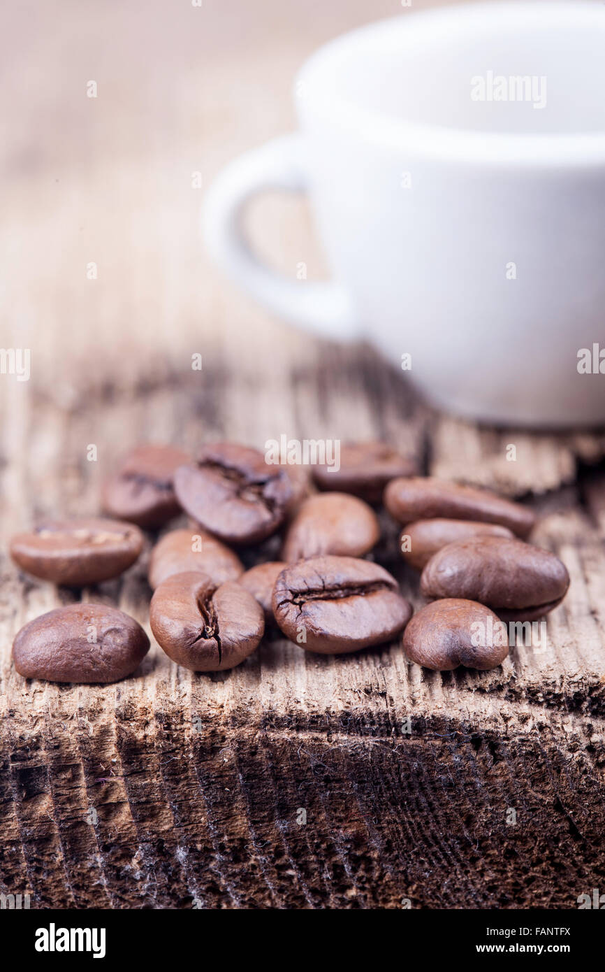 Tasse und Getreide Kaffee auf groben hölzernen Oberfläche closeup Stockfoto