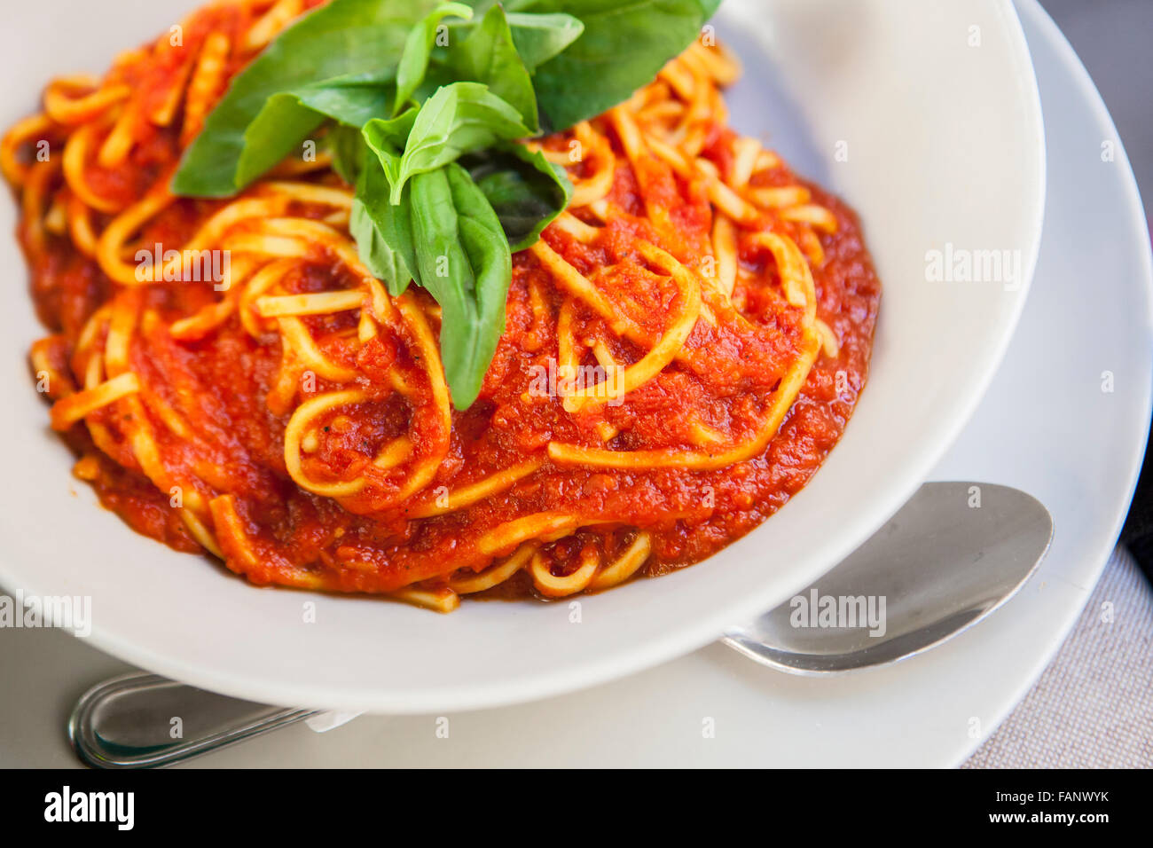 Teller mit Spaghetti Bolognese mit Basilikum garnieren. Nahaufnahme mit selektiven Fokus erschossen Stockfoto
