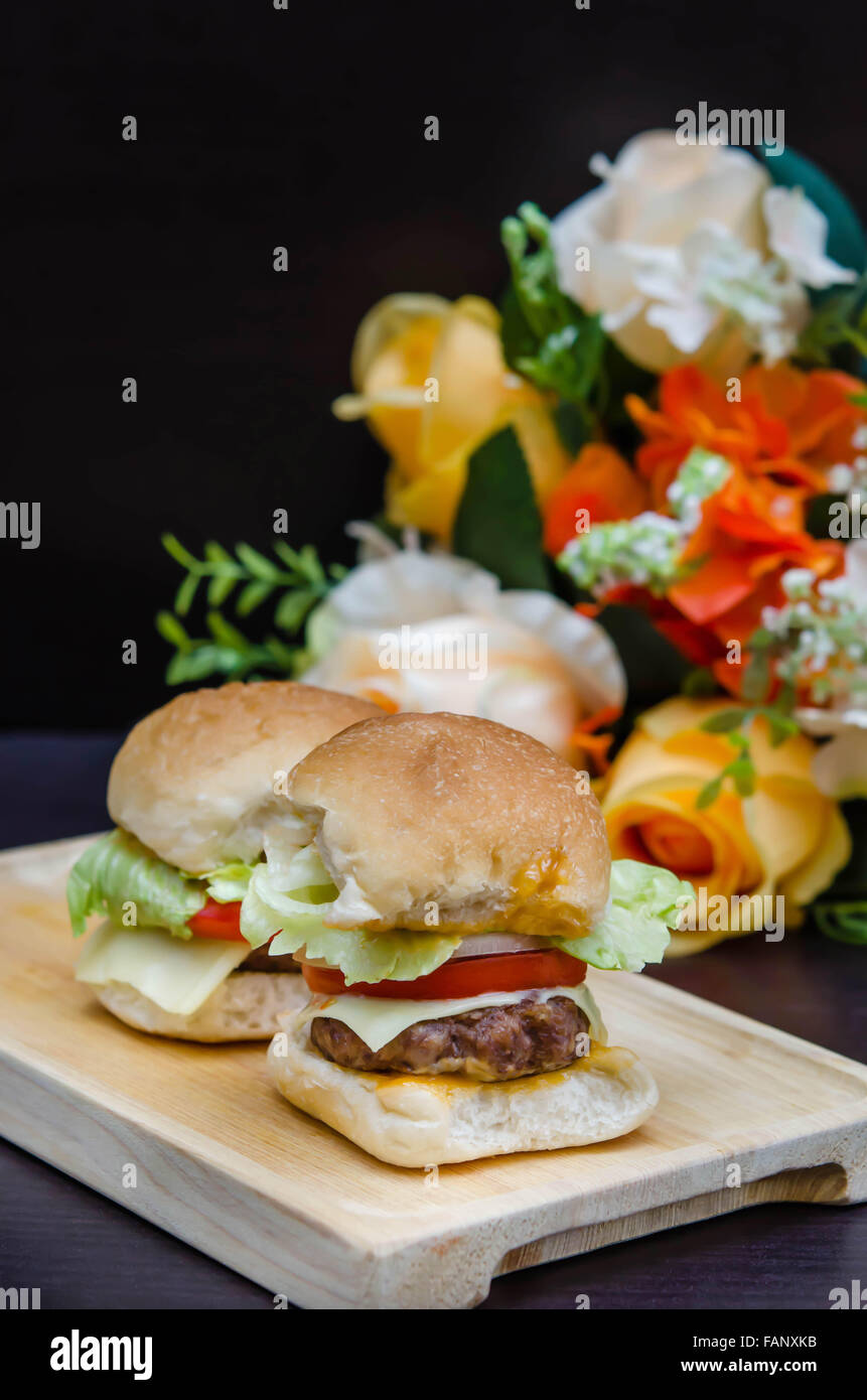 Köstlichen hausgemachten Gourmet-Käse Burger vom Rind mit frischen Zutaten, die auf hölzernen Platten gelegt Stockfoto