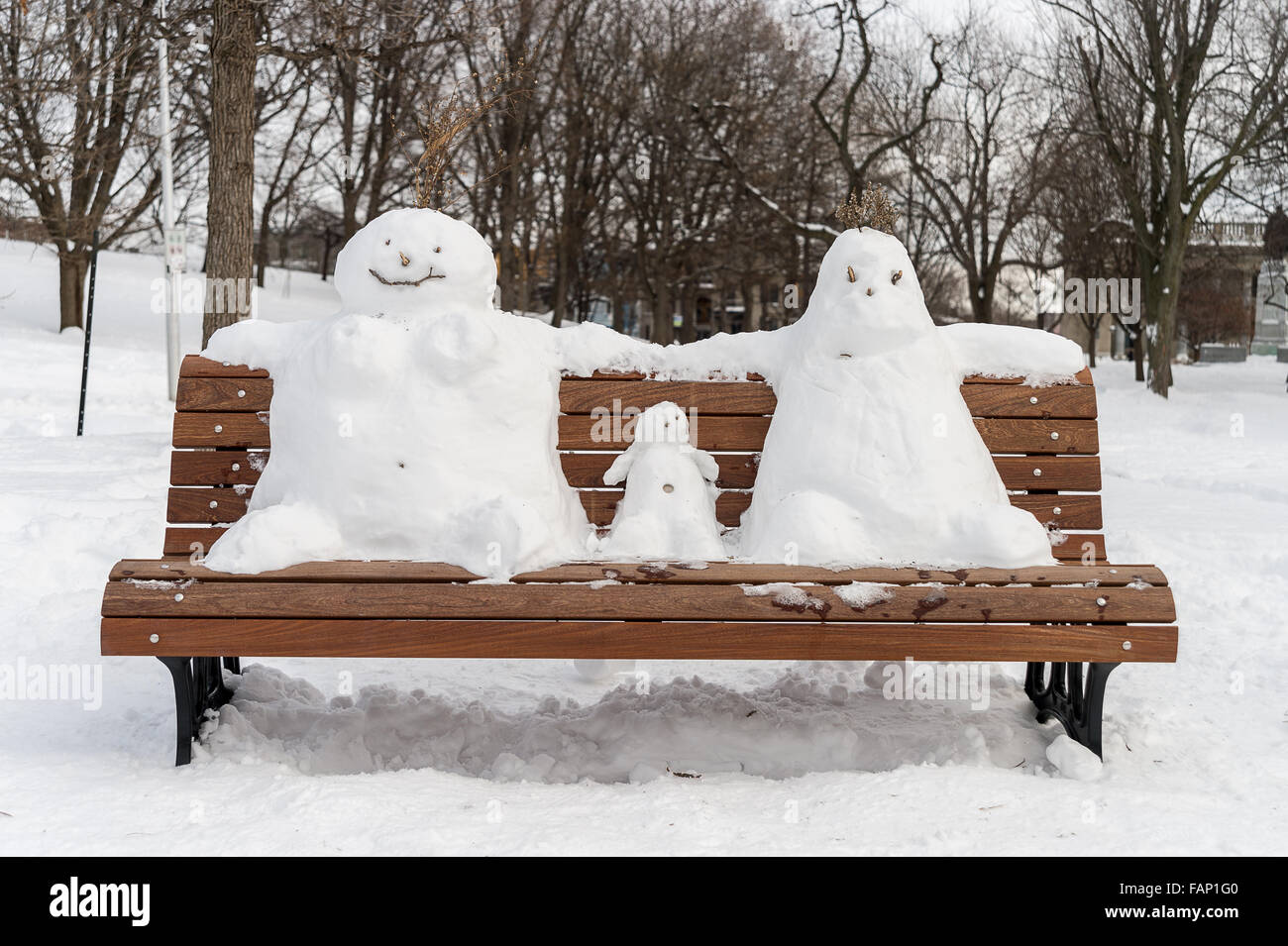 Der Schneemann auf einer Bank Familie: Vater, Mutter und Kind Stockfoto