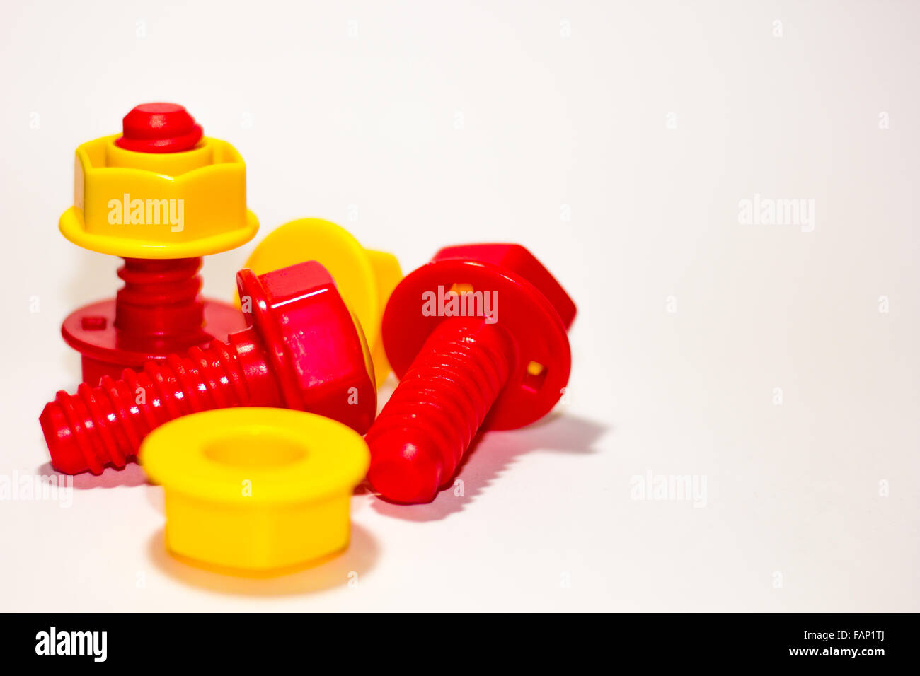 Gelbe und rote Schrauben und Muttern Stockfoto