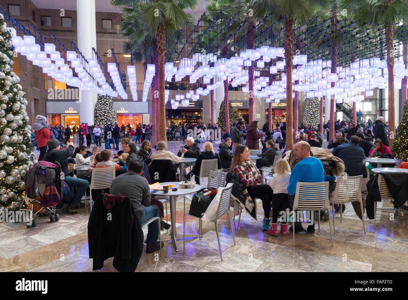 Besucher und Käufer sitzen unter hängenden Laternen im Atrium des Brookfield Place während der Ferienzeit in New York City. Stockfoto