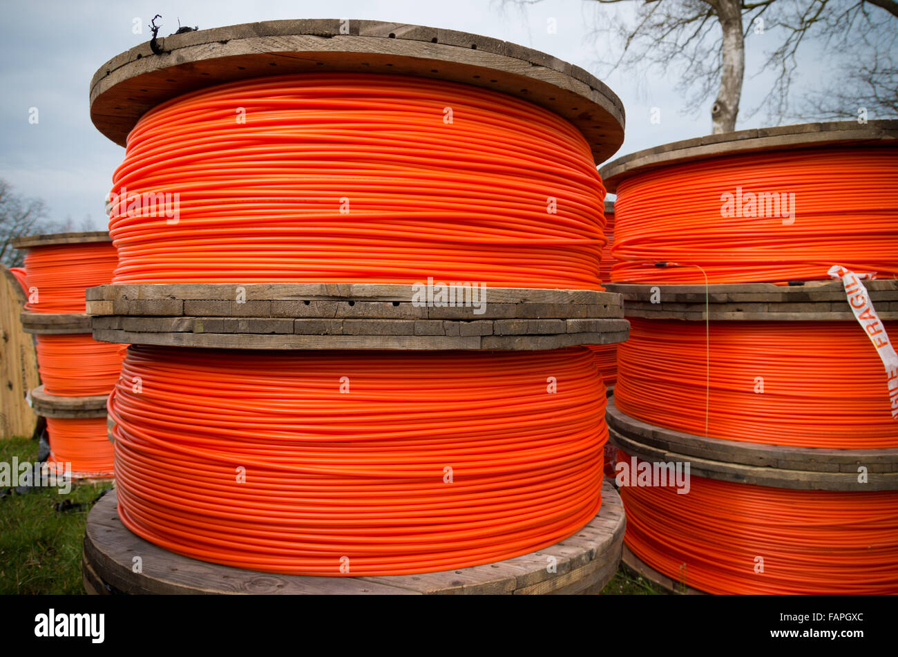 große Trommeln mit orange Glasfaserkabel auf einer Baustelle Stockfoto