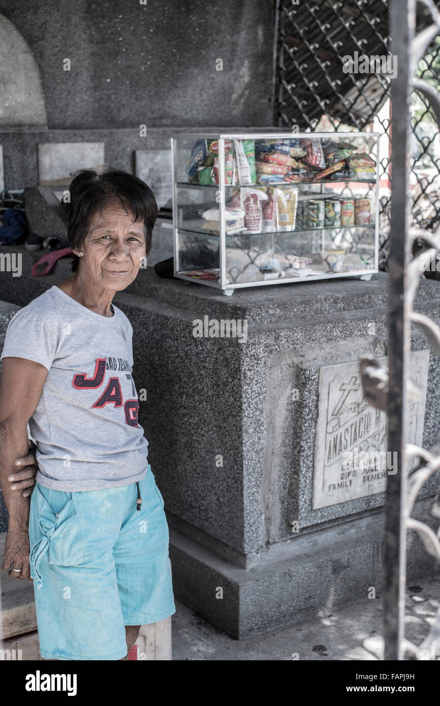 Eine alte Dame, Verkauf von Produkten auf einem Friedhof in Manila, Philippinen Stockfoto