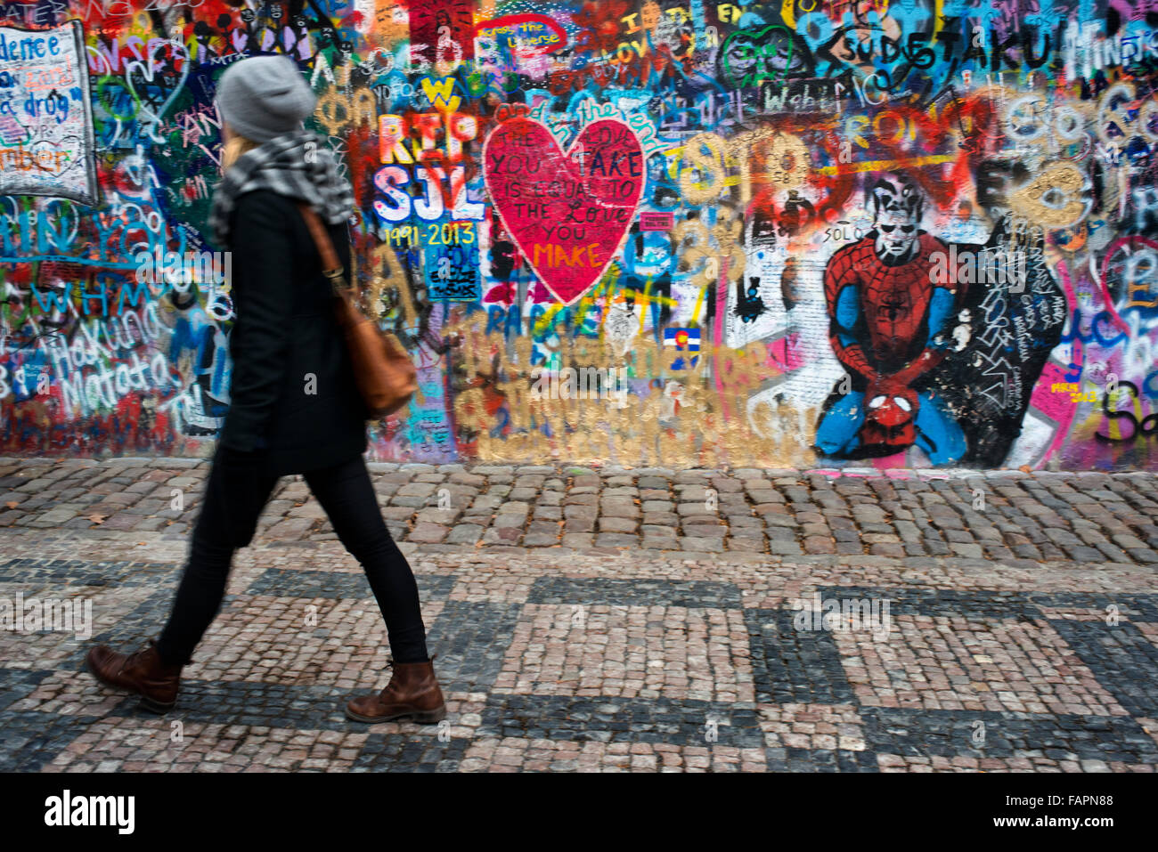 Eine Mädchen geht vorbei an der John-Lennon-Mauer im Zentrum von Prag. Die John-Lennon-Mauer ist eine Mauer, die einst einen Großteil der könnte Stockfoto