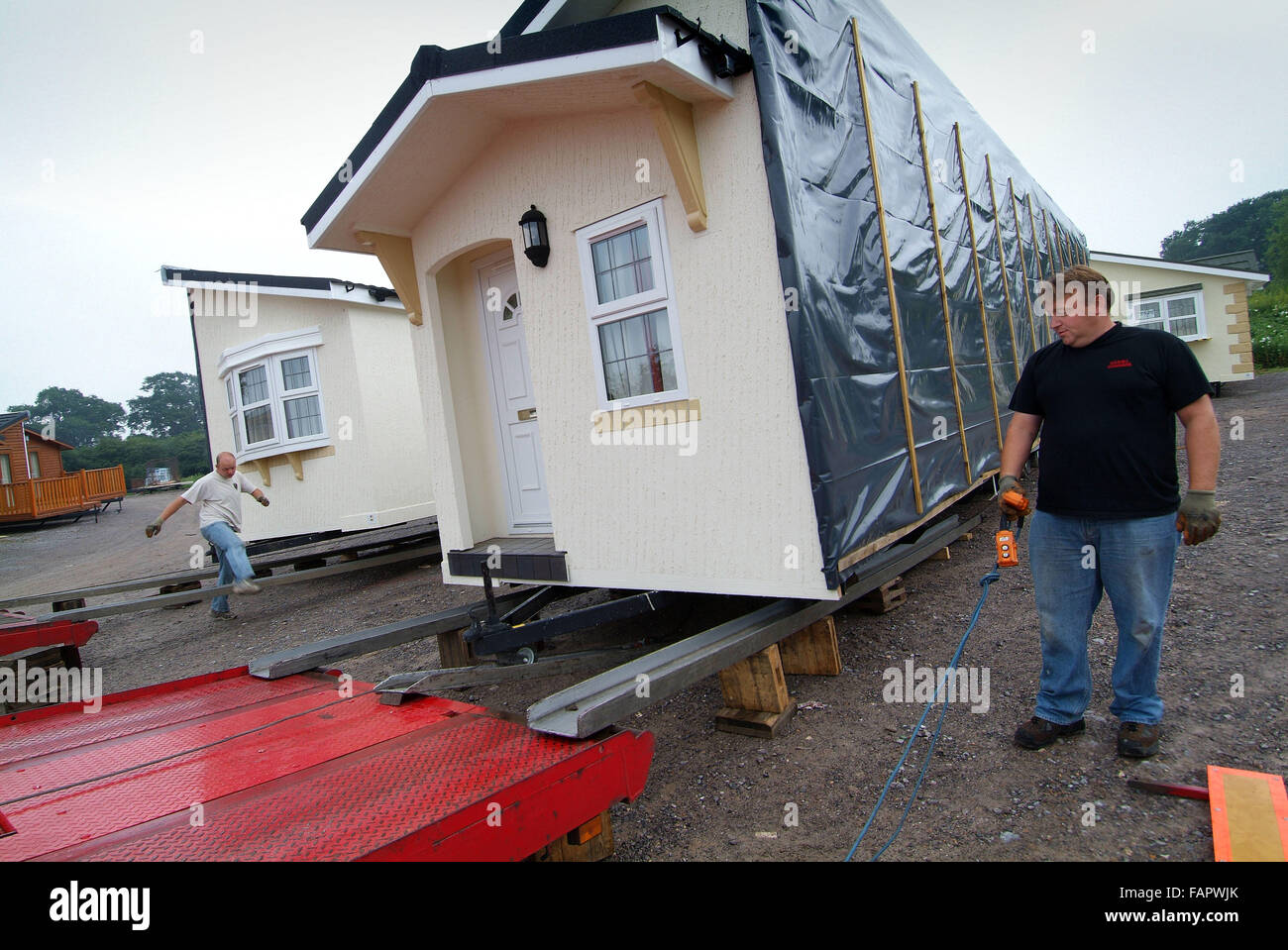 Wessex Wohnungen prefabricate Häuser, die in 2 Hälften auf Sattelschlepper auf permanente Standorte transportiert werden. Eine britische Gehäuse Lkw Stockfoto