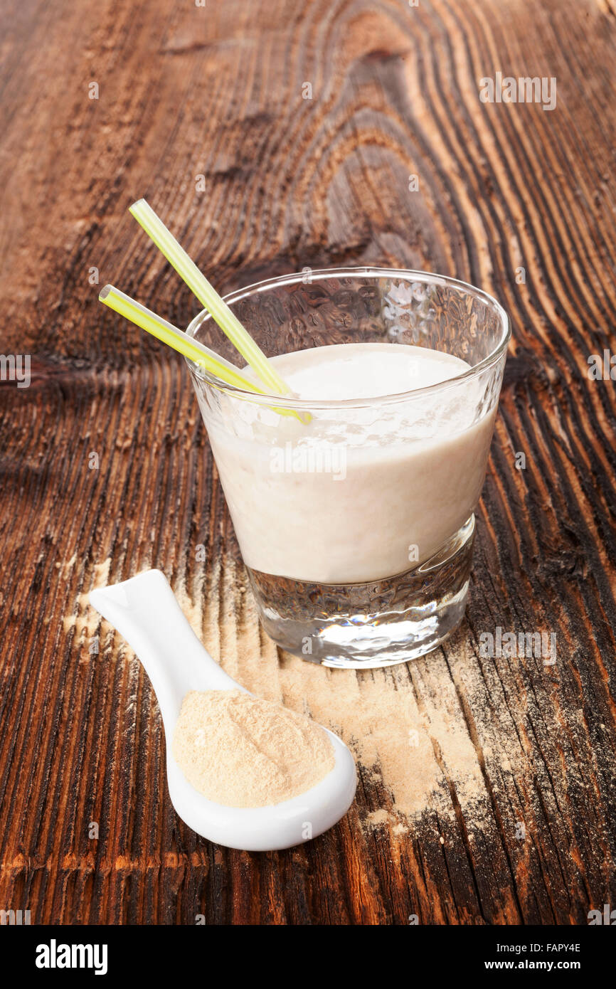 Maca Pulver auf Löffel und Maca Pulver schütteln auf braun alter Holztisch. Gesundes Wohnen, alternative Medizin, rustikalen Stil. Stockfoto