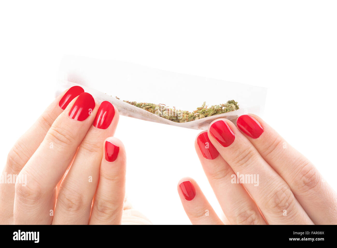 Hände, die isoliert auf weißem Hintergrund rollt ein Cannabis gemeinsame. Rauchen Marihuana sucht. Feminine Drogenmissbrauch. Stockfoto