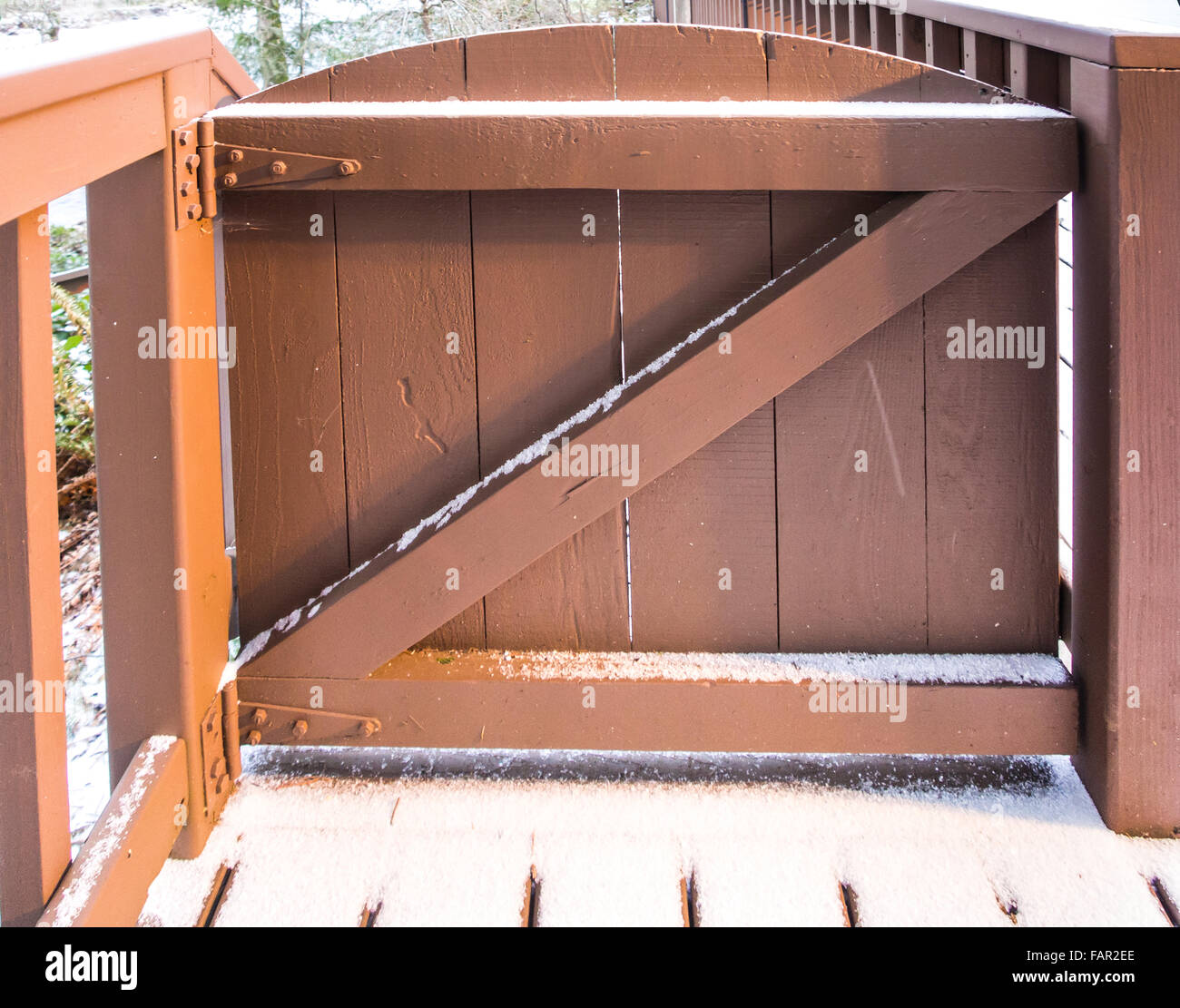 Geschlossen braune Holztor mit Schnee hautnah. Das Design ist der Buchstabe Z mit 2x4. Stockfoto