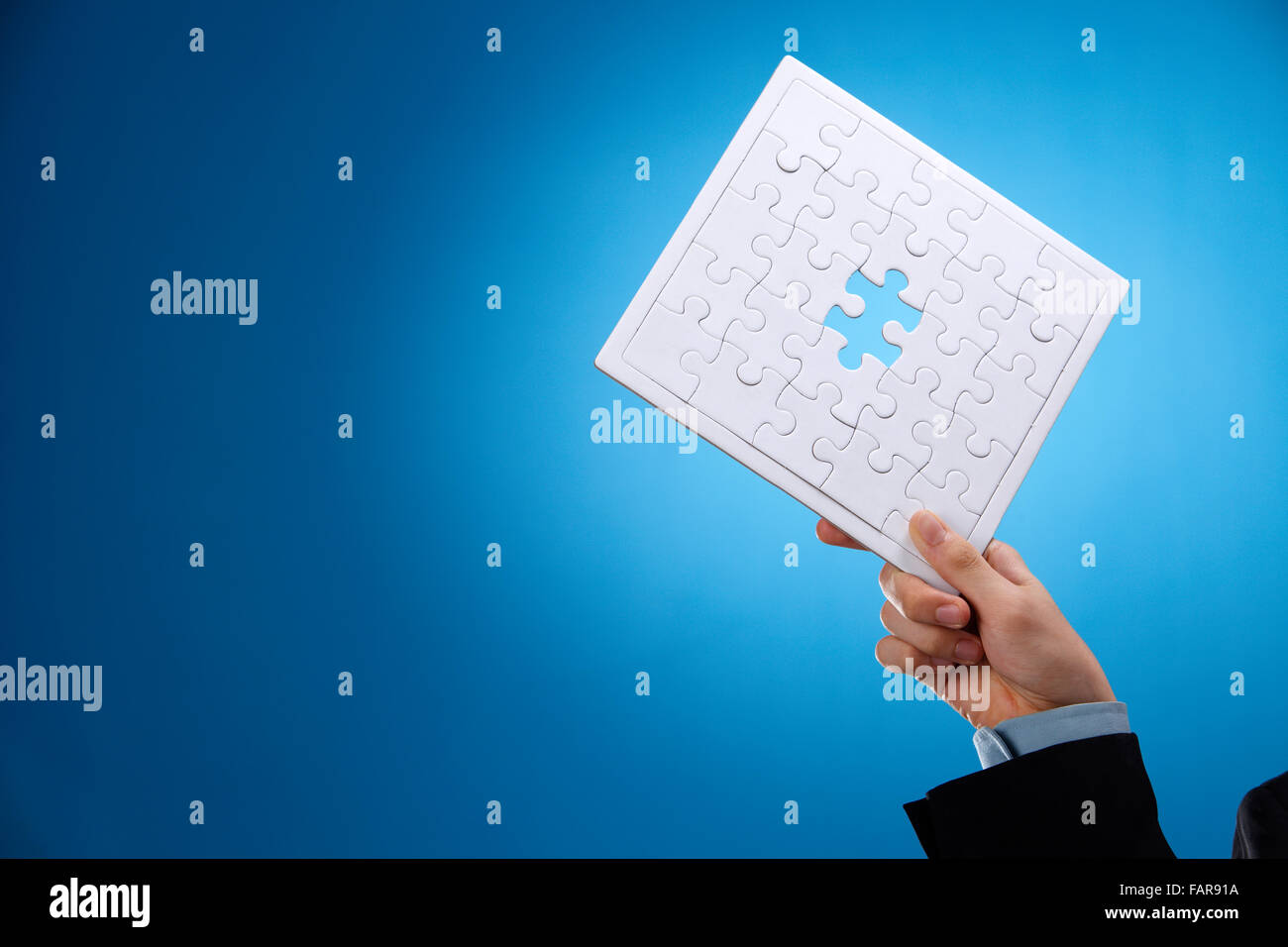 Menschliche Hand halten eines unvollständigen Puzzles. Stockfoto