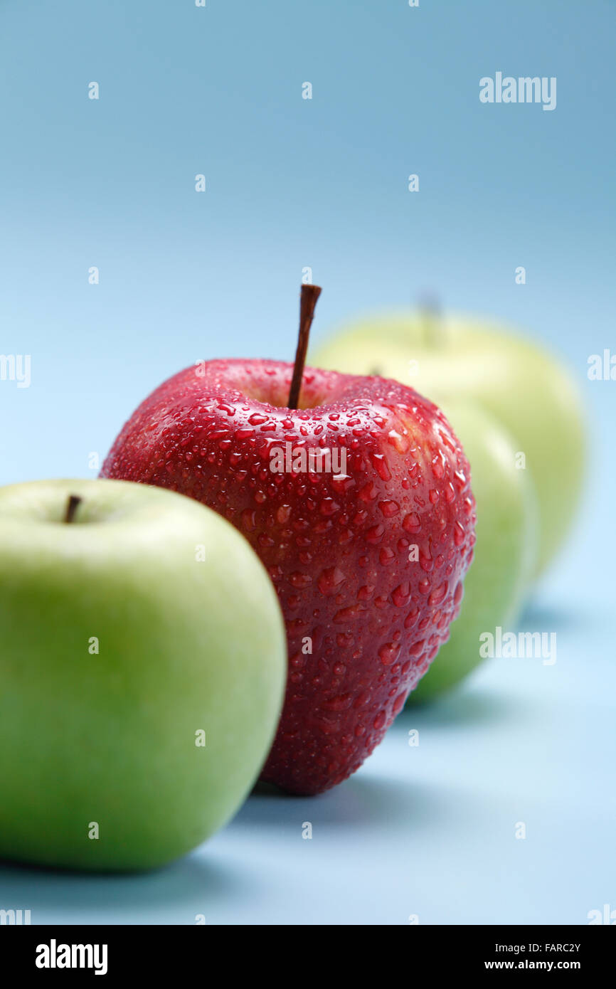 Unterschiedliche Konzepte - roter Apfel zwischen grünen Äpfeln Stockfoto