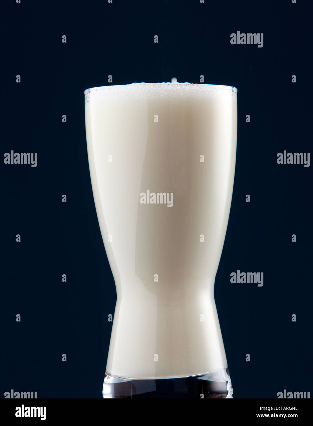 Volles Glas Milch auf dunklem Hintergrund Stockfoto