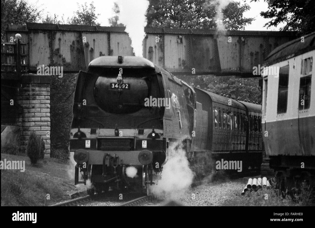 Bahnhof Haworth, West Yorkshire circa 1982 schwarz-weiß Archiv Bild. Heimat der Keighley und Wert Valley Railway, ist die KWVR mit freiwilligen besetzt. BRITISH RAILWAYS, BULLEID WEST COUNTRY PACIFIC 4-6-2 Nr. 34092 'CITY OF WELLS' 1949 erbaut und ursprünglich den Namen "Brunnen" dampft unter Brücke. Stockfoto