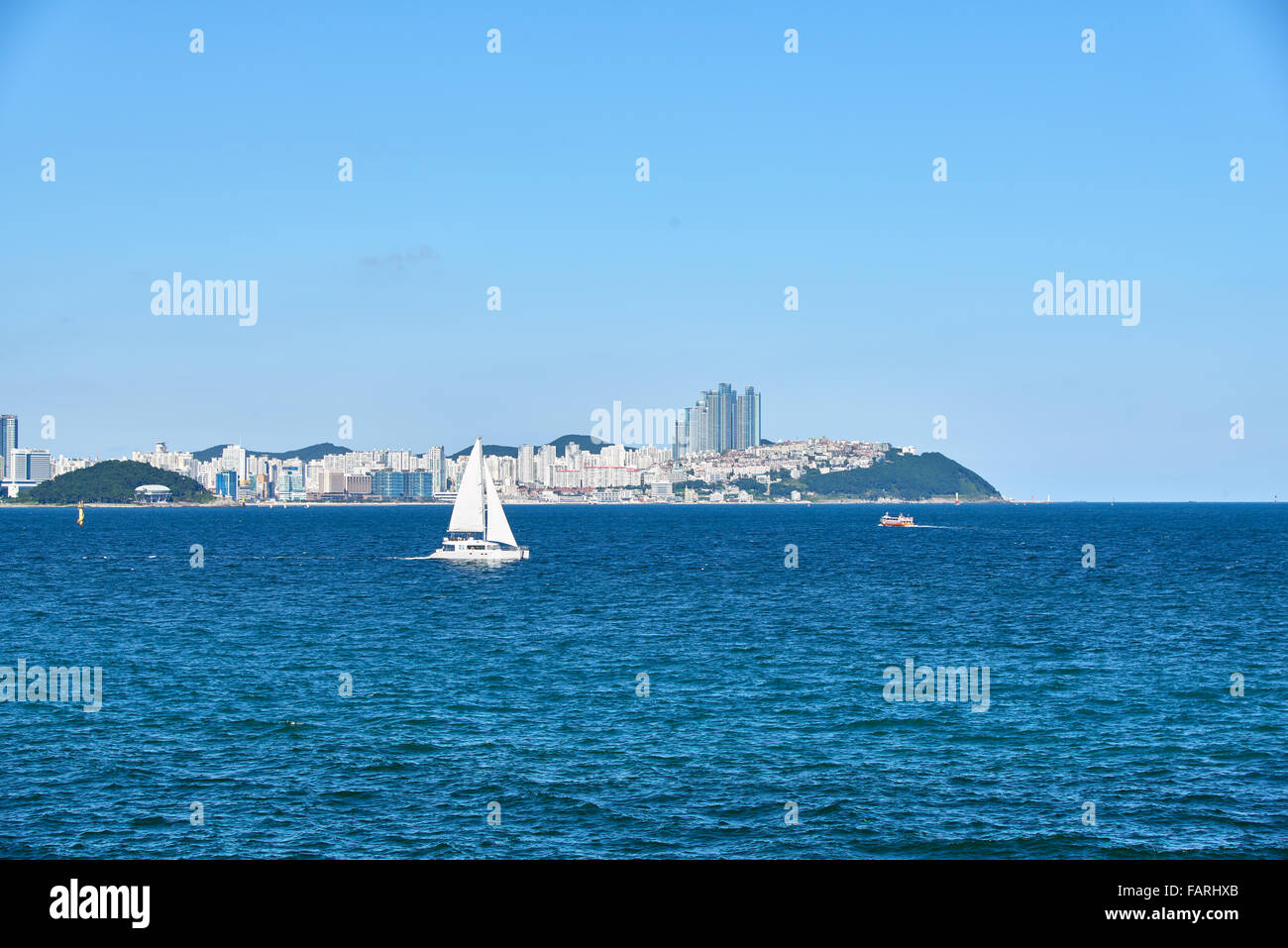 weiße Luxus-Yacht Segeln auf dem Meer auf einem Hintergrund von Haeundae in Busan, Korea. Stockfoto