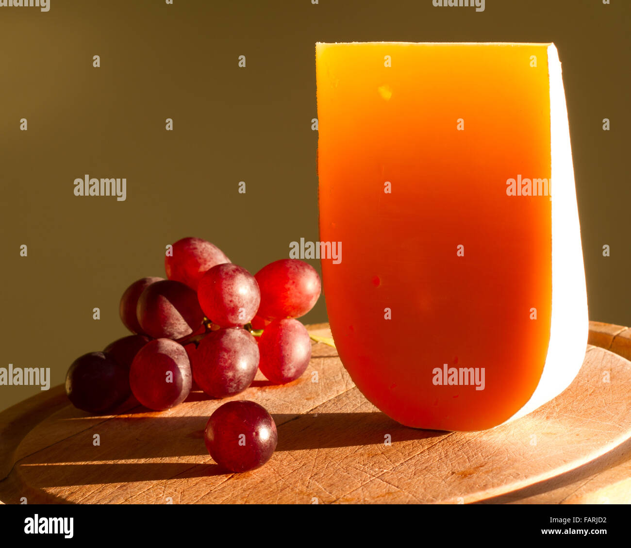 Gelben Stück Käse abstrakte Stilleben mit Trauben closeup Stockfoto