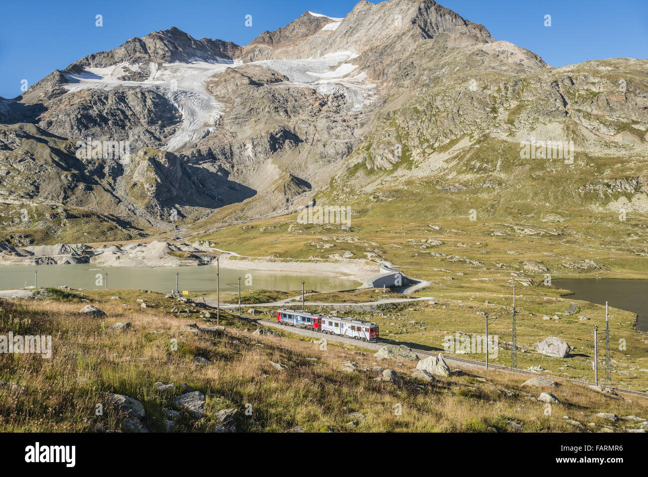 Express-Zug im Lago Bianco auf dem Berninapass, Graubünden, Schweiz Stockfoto