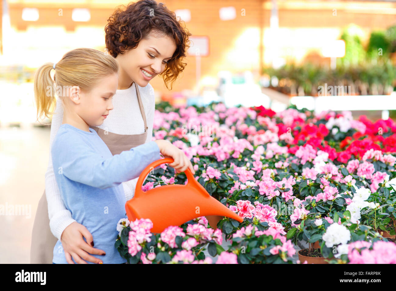 Kleine Mädchen und Blumengeschäft Blumen gießen. Stockfoto