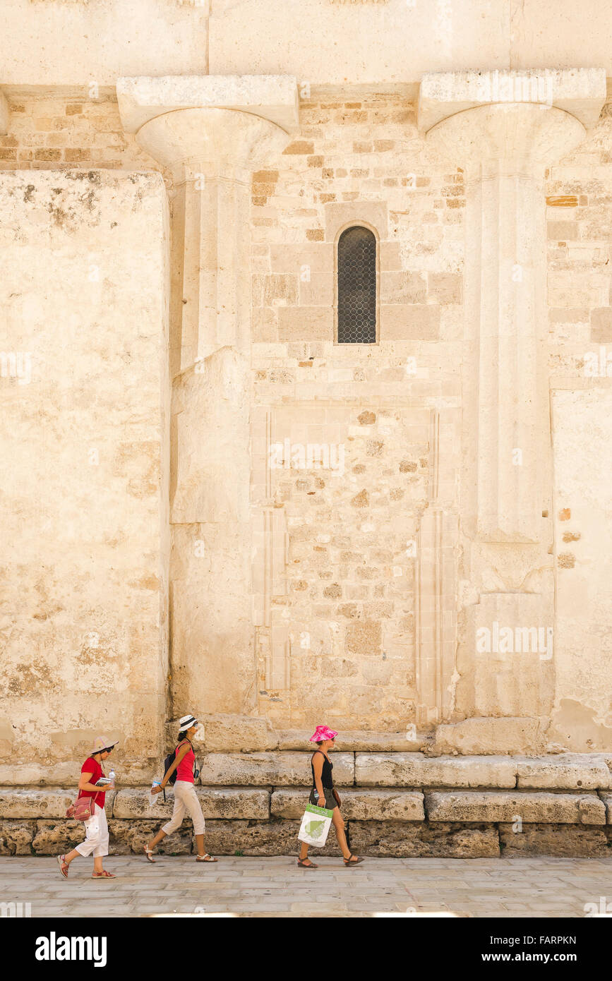 Touristen Sizilien, drei Frauen Touristen zu Fuß durch ein Paar der alten griechischen Säulen im Dom (Kathedrale) Wand in Ortigia, Syrakus, Sizilien eingebettet. Stockfoto
