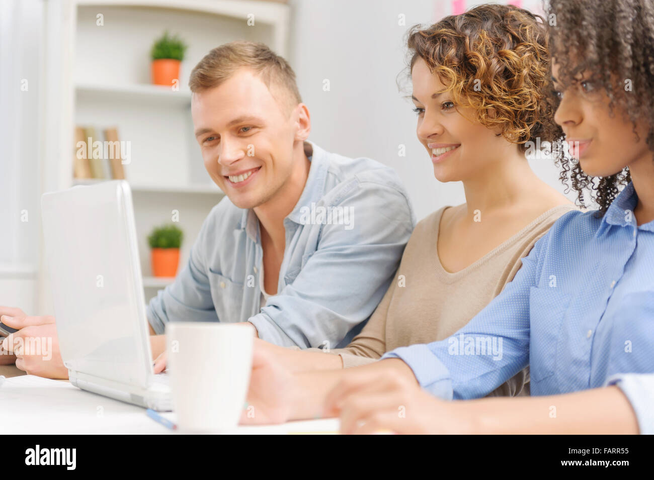 Drei junge Menschen arbeiten im Büro. Stockfoto