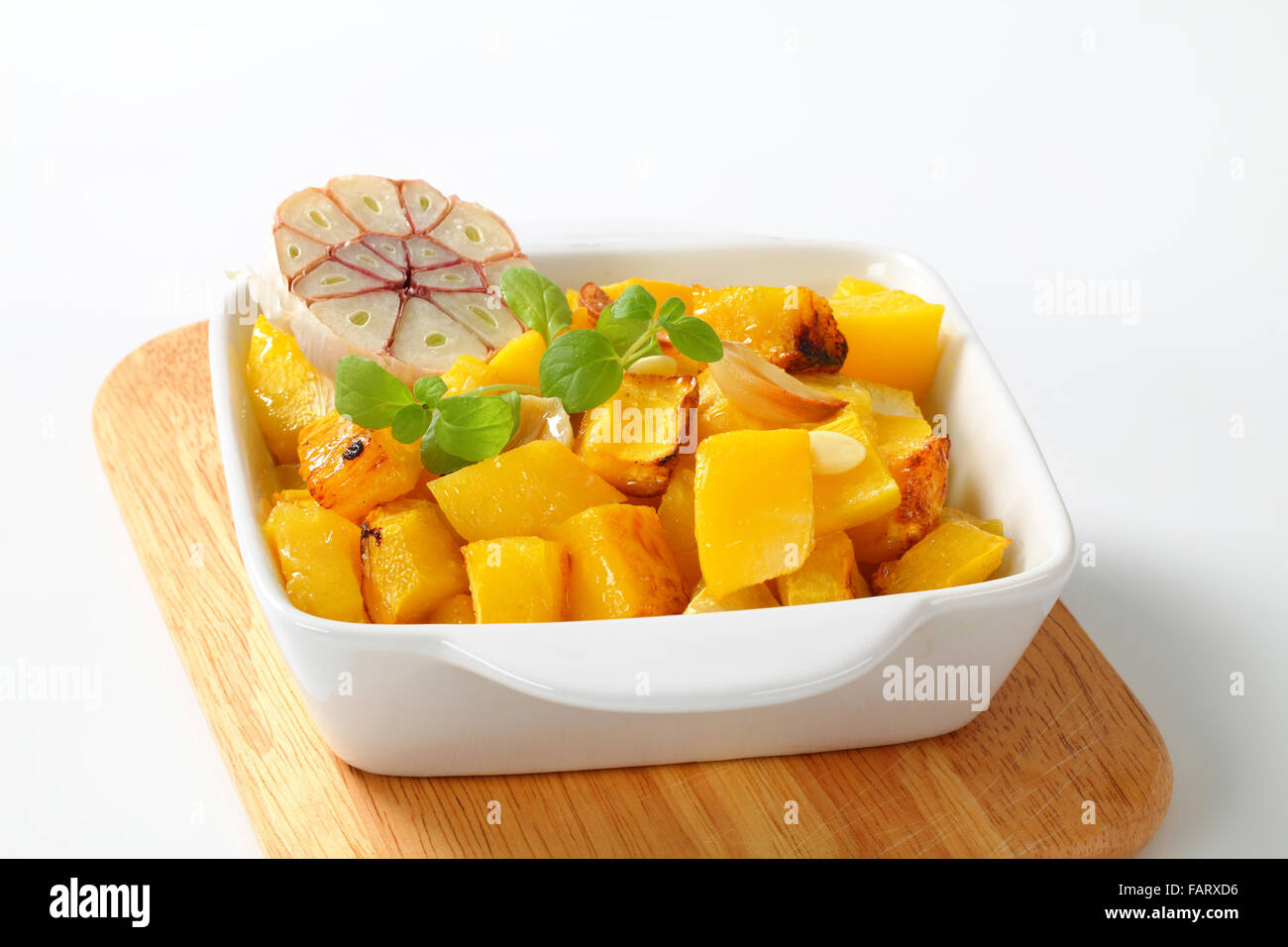 Gebratene Kürbiswürfel und Knoblauch in quadratische Auflaufform Stockfoto