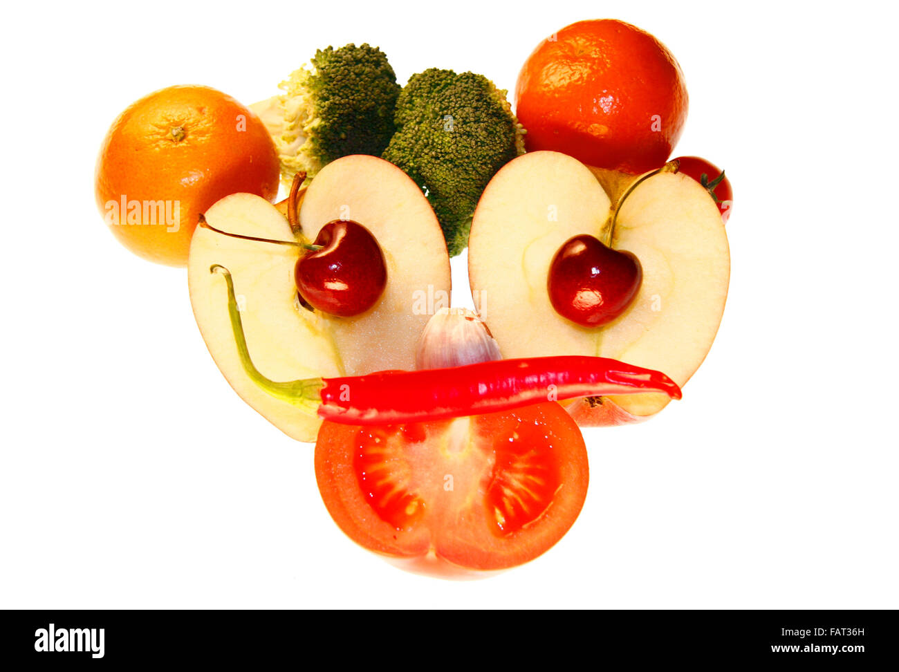 On / Gesicht: Brokkoli, Clementinen, Knoblauch, Kirschen, Apfel, Tomate, Chilly - Symbolbild Nahrungsmittel. Stockfoto