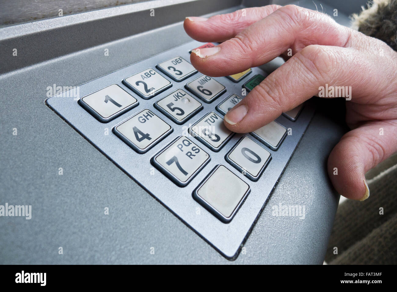 Frau, die Eingabe ihrer PIN an einem Geldautomaten. Stockfoto