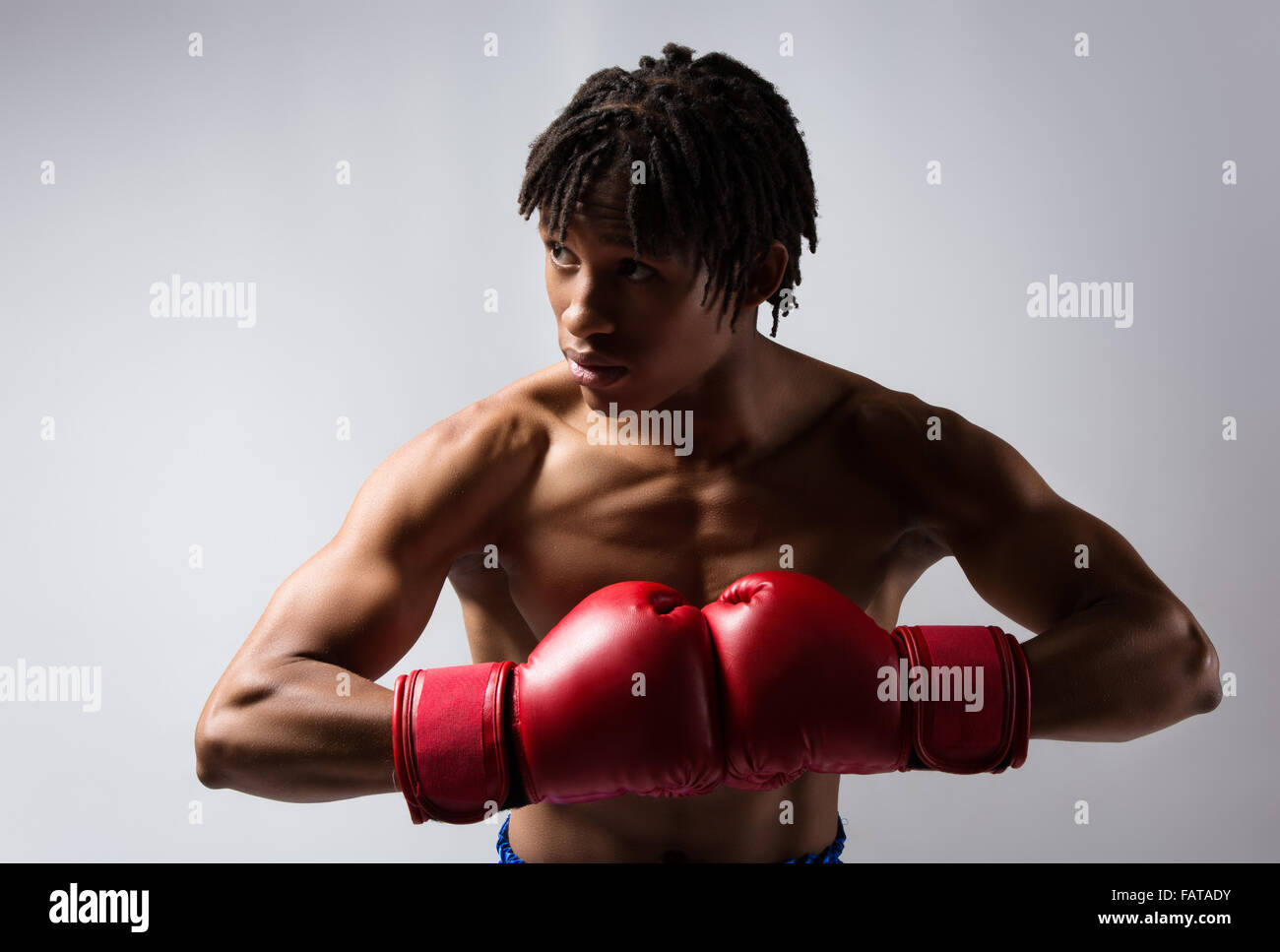 Junge muskulöse athletische männliche Boxer blaue Boxershorts und rote Boxhandschuhe. Stockfoto