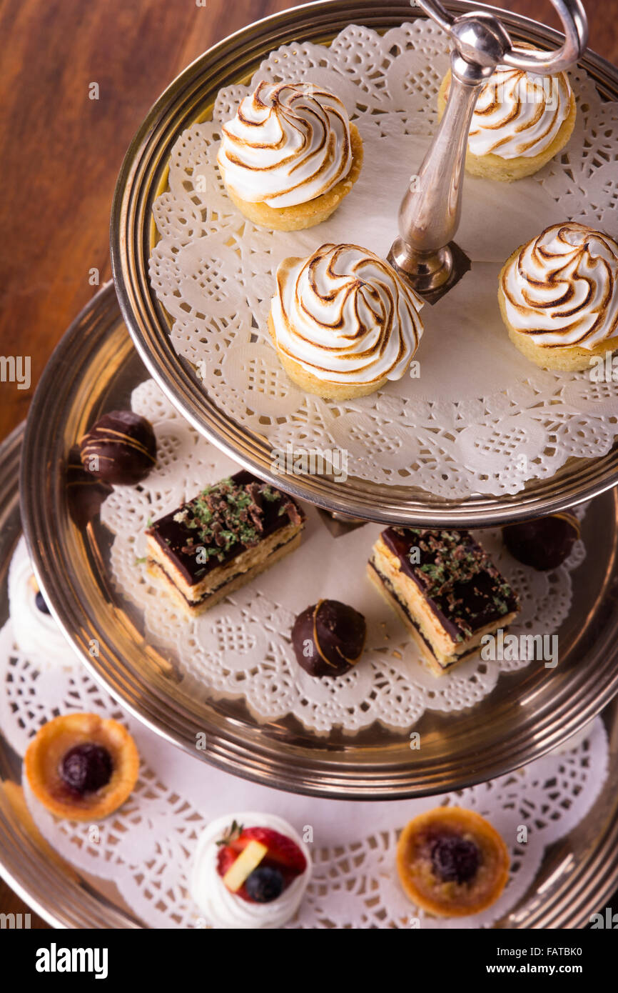 Eine Auswahl an leckeren Desserts angeordnet und auf eine silberne Etagere im Stil eines englischen High Tea serviert. Stockfoto