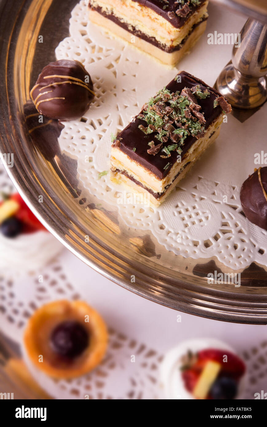 Eine Auswahl an leckeren Desserts angeordnet und auf eine silberne Etagere im Stil eines englischen High Tea serviert. Stockfoto