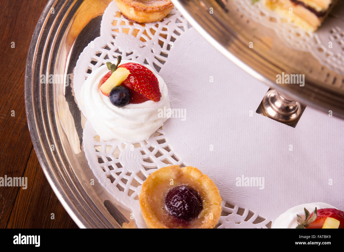 Eine Auswahl an leckeren Desserts angeordnet und auf eine silberne Etagere im Stil eines englischen High Tea serviert. Stockfoto