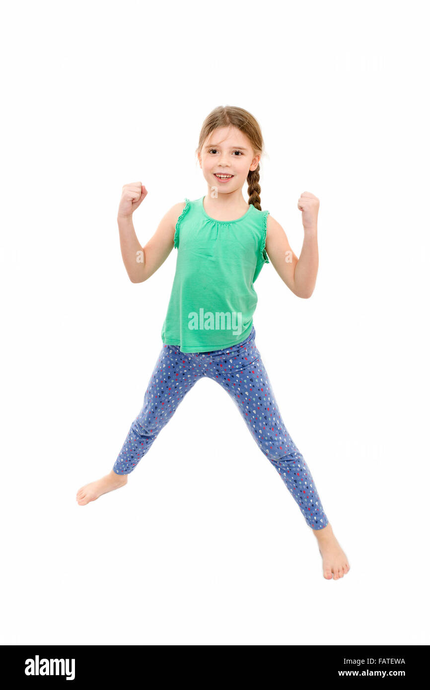 junge Mädchen tragen blaue Leggings und grüne Weste Übungen auf weißem Hintergrund Stockfoto