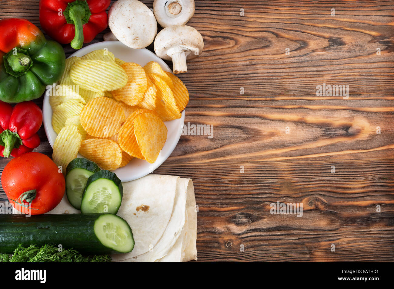 Chips und Gemüse auf dem hölzernen Hintergrund. Stockfoto
