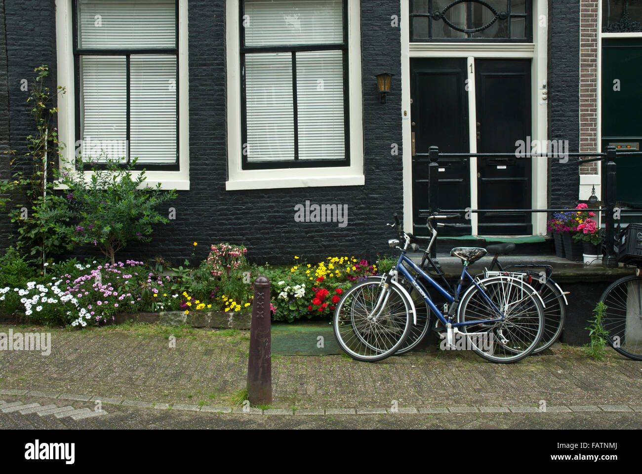 Alte Amsterdam, Holland. Typische Szene der Fahrräder und bunten Blumen außerhalb der typischen alten Haus in der Altstadt von Amsterdam, Holland. Stockfoto