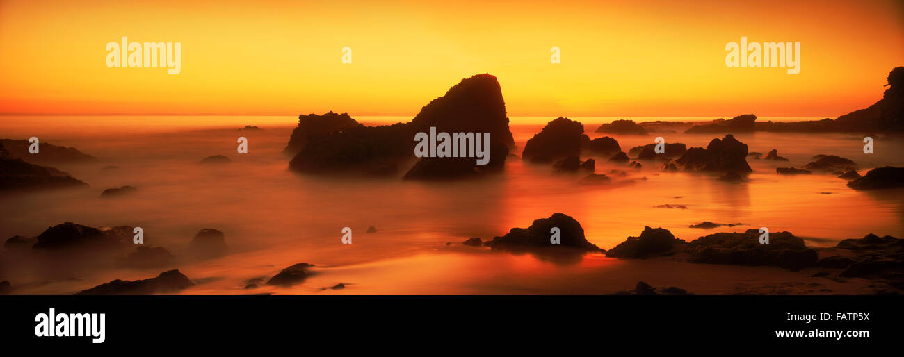 Sonnenuntergang Himmel Malerei Felsen und Sandstrand in Laguna Beach, Kalifornien Stockfoto
