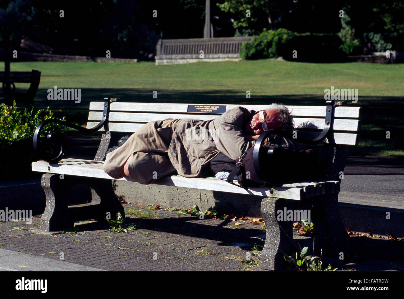 Obdachloser schlafen auf Parkbank, Downtown Vancouver, BC, British Columbia, Kanada Stockfoto