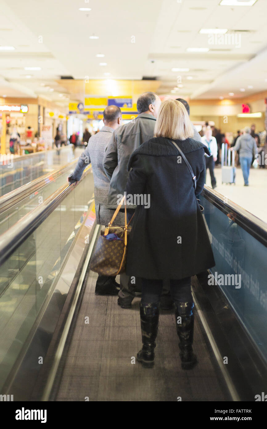 Passagiere auf dem sich bewegenden Gang im Flughafen Stockfoto