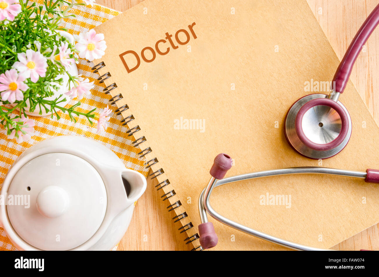 Stethoskop mit Notizbuch mit Blume auf Holz Hintergrund. Stockfoto