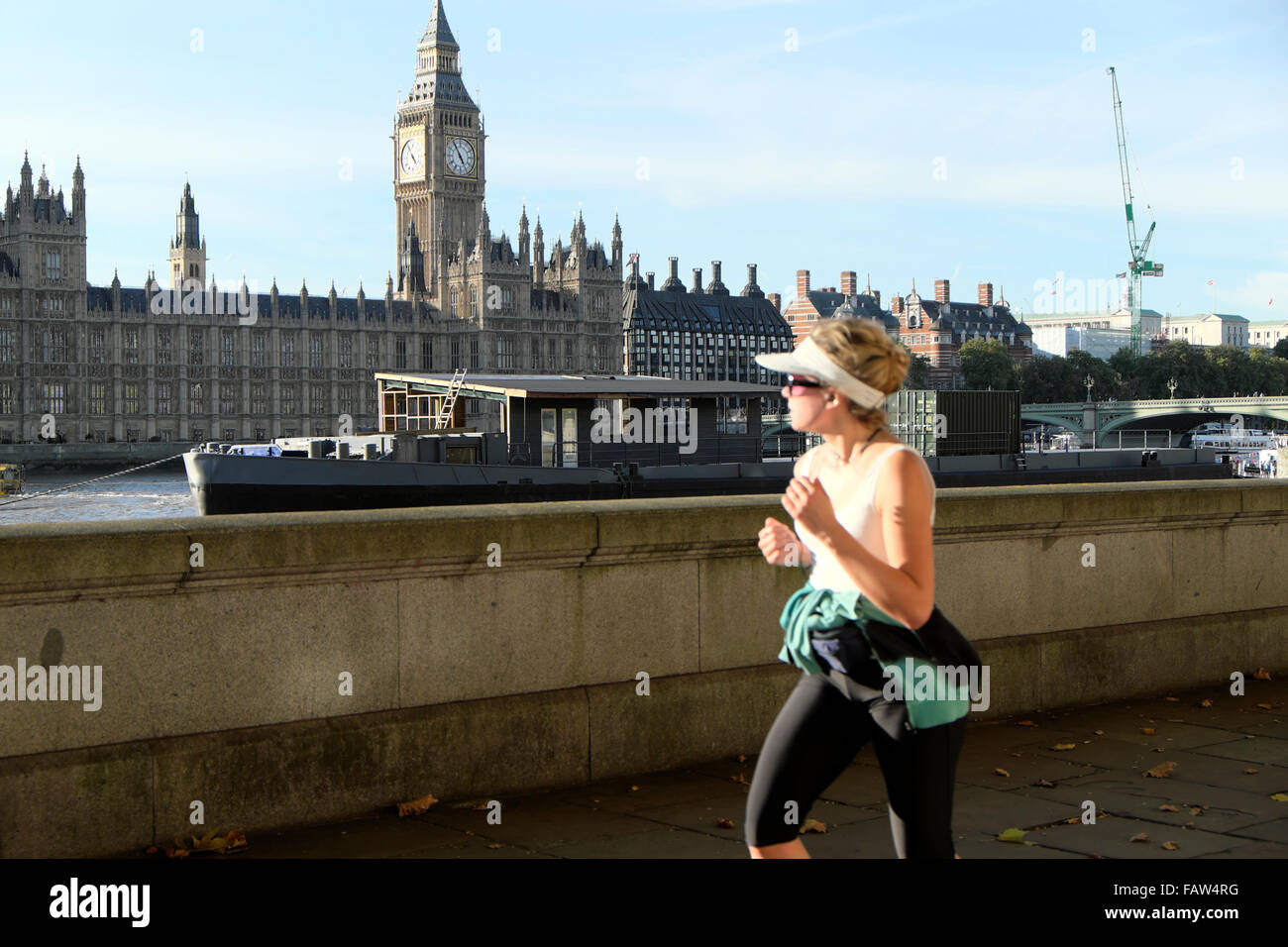 Eine Joggingjoggerin am Südufer der Themse mit Blick auf Big Ben und Houses of Parliament in London England Großbritannien KATHY DEWITT Stockfoto