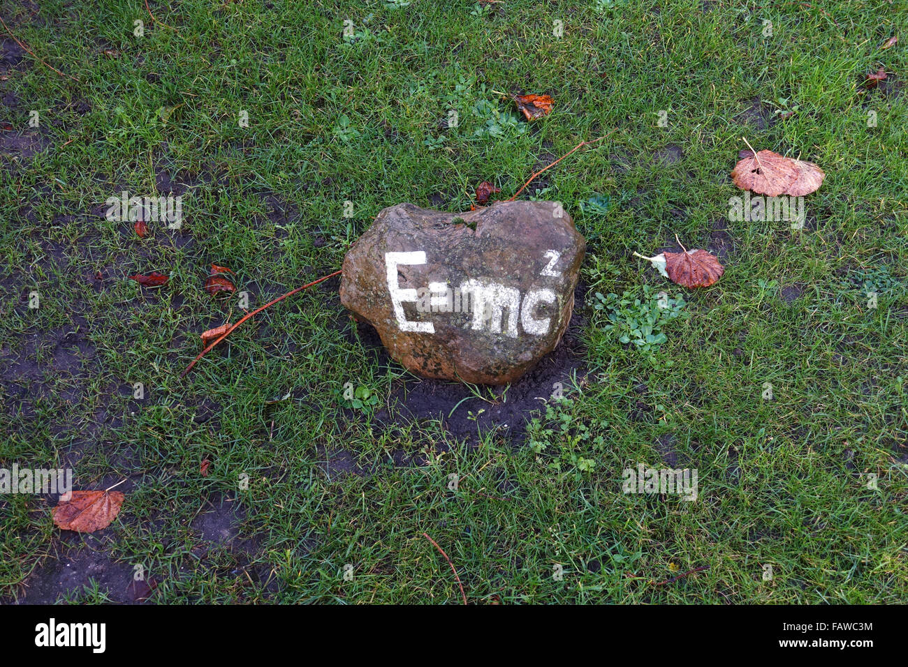 Die Formel "E = mc2", die Masse – Energie-Äquivalenz, steht auf einem Stein, der auf dem Rasen, fotografiert im Herbst in Nieblum auf Föhr Insel (Schleswig-Holstein), Deutschland, 20. November 2015 liegt. Foto: Jens Kalaene - kein Draht-Dienst- Stockfoto