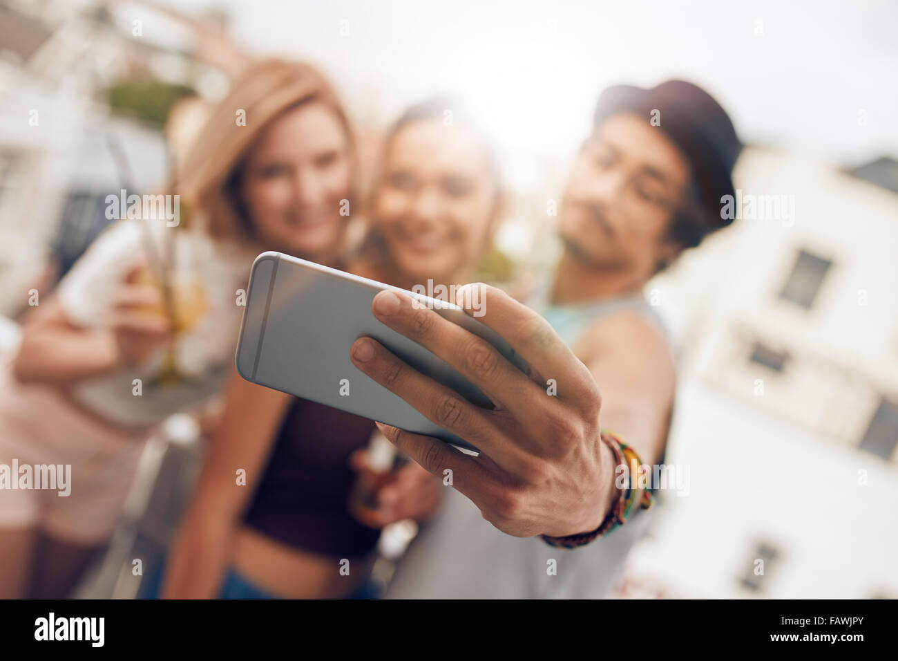 Junge Freunde in einer Partei unter Selbstbildnis mit ihrem Smartphone. Handy in die Hand des Menschen im Mittelpunkt. Stockfoto