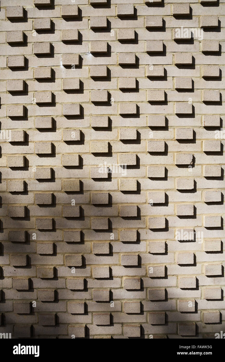 Ziegelwand mit Ziegeln, die über die Wand hinausreichen, mit Schatten. Modernes Design, London, Großbritannien. Hintergründe und Texturen. Backsteinwand Hintergrund. Stockfoto