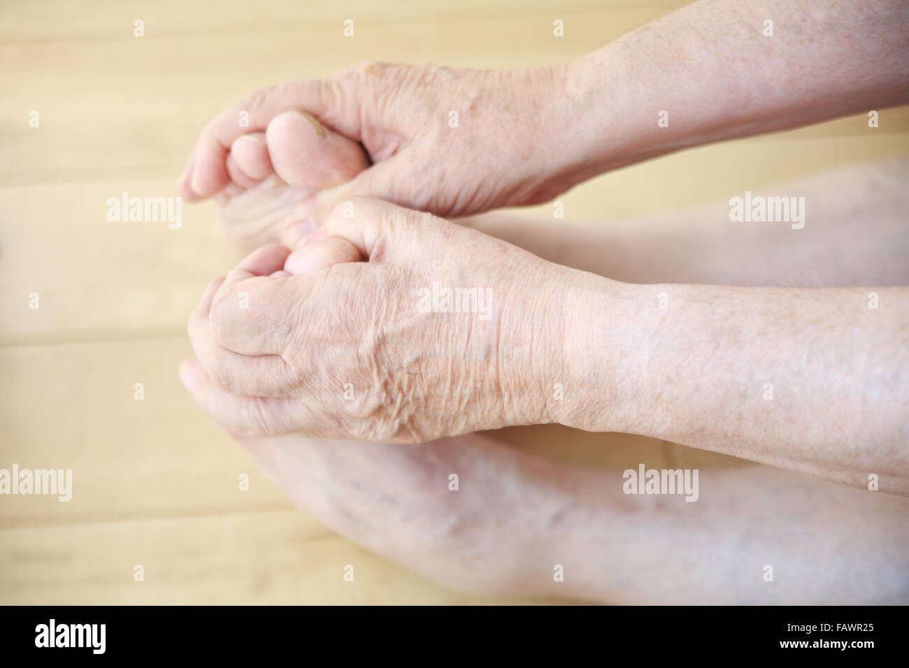 Senior woman erstreckt, und hält seine Zehen. Stockfoto