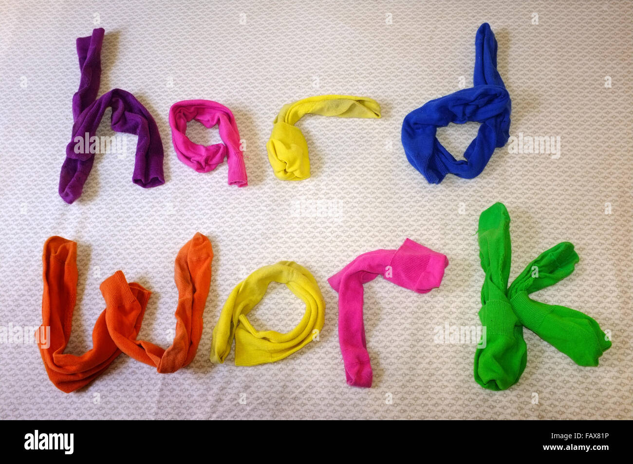 Die Worte harte Arbeit aus bunten Socken einen Bettbezug Handauflegen gemacht. Stockfoto