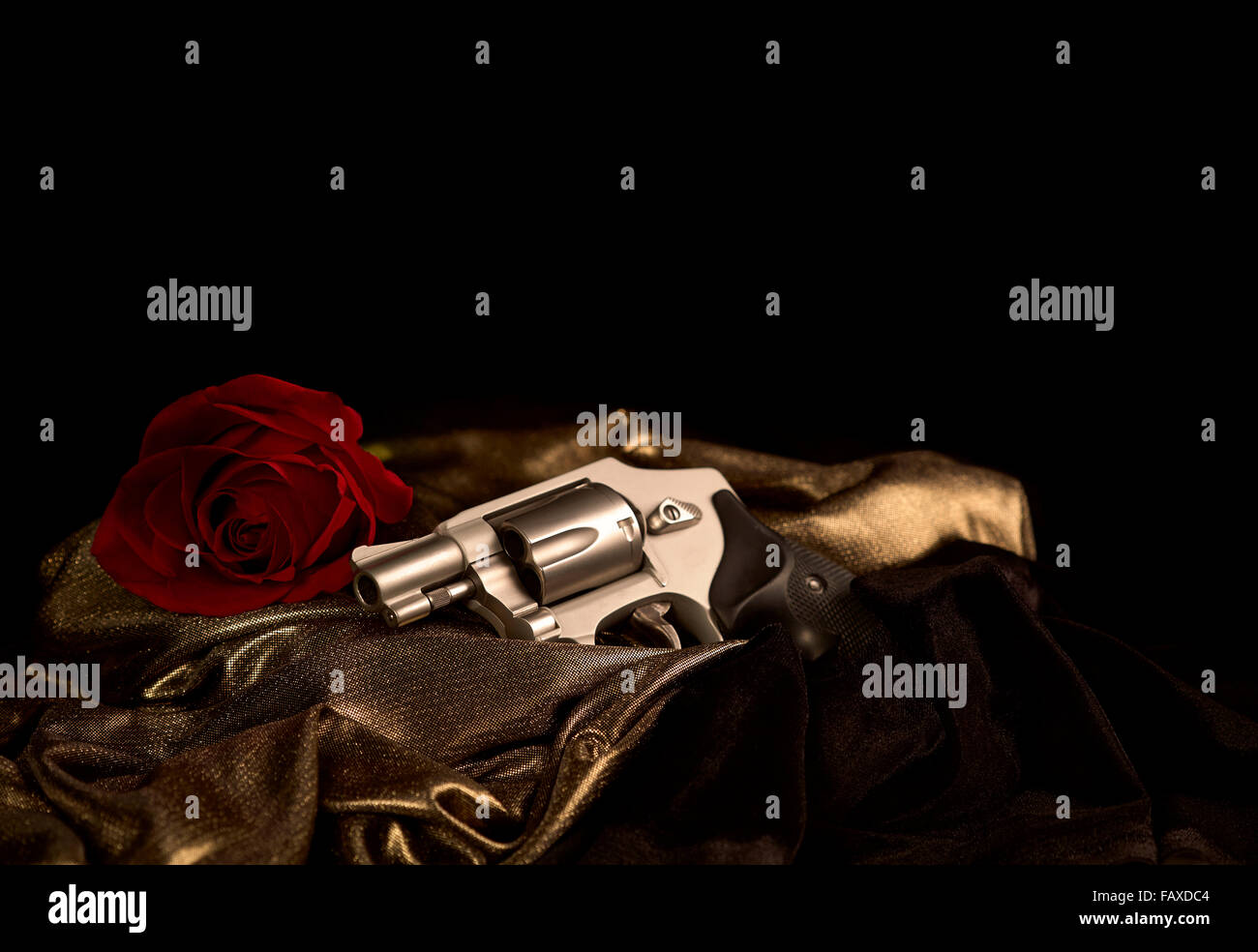 Snubnose 38 Revolver Verlegung über Gold satin mit einer roten rose und schwarz samt Stockfoto