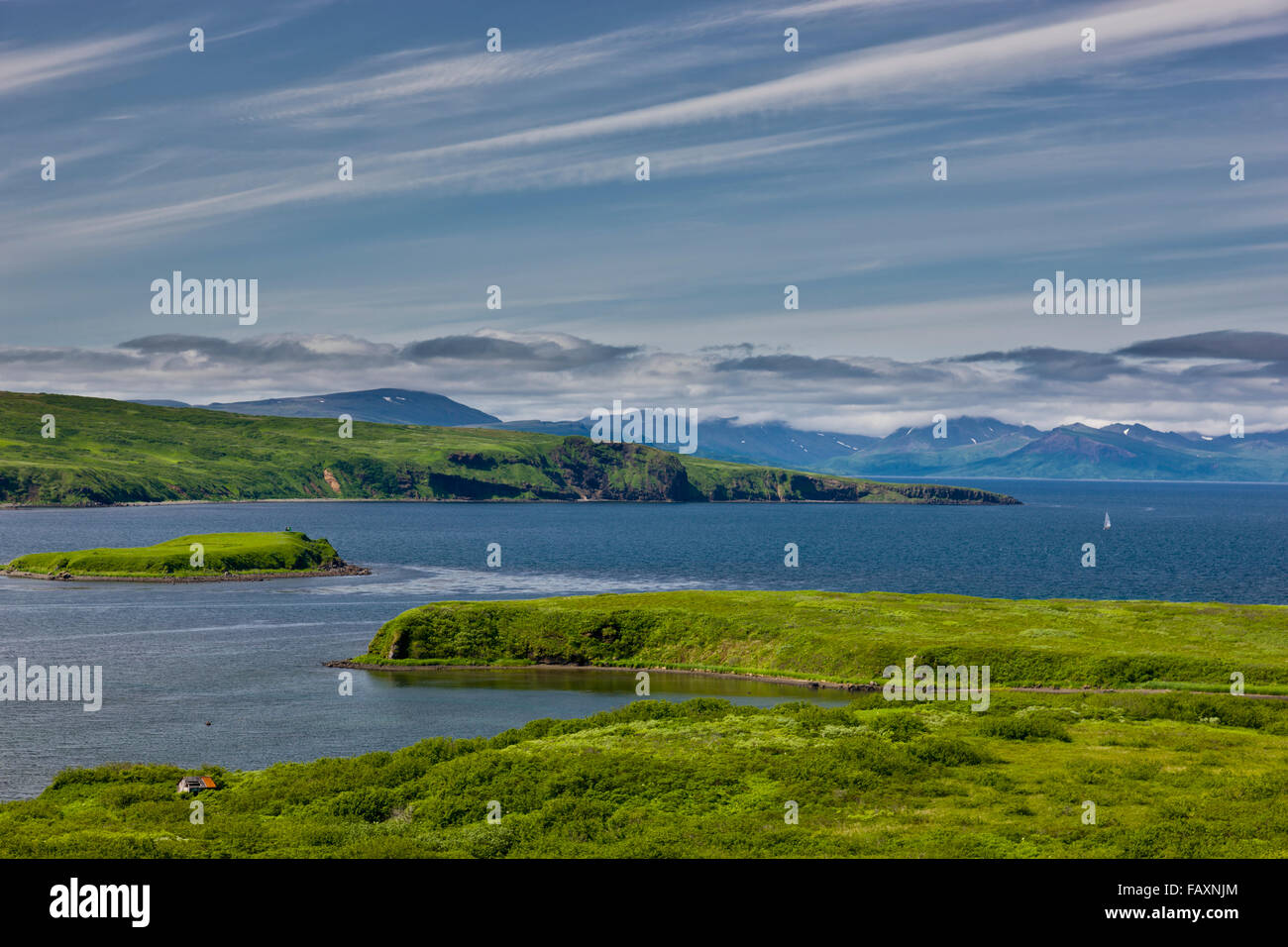 Ein kleines Gebäude liegt an der Küste von Sand Point, mit Inseln und Bergen im Hintergrund, Sand Point, südwestlichen Alaska, USA, Sommer Stockfoto