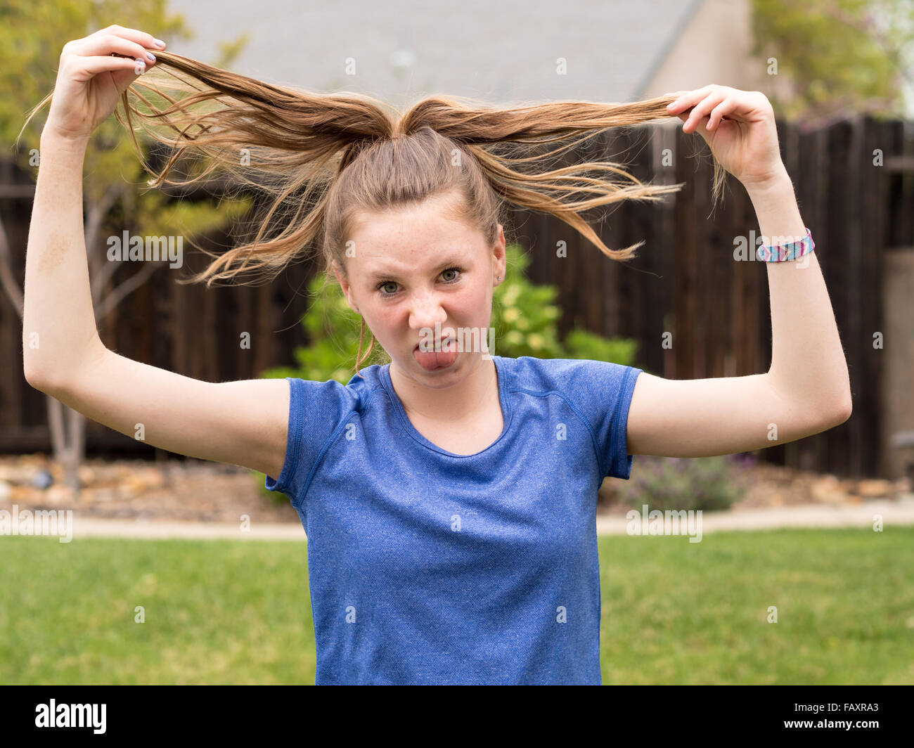 Teenager hochhalten zerzaustes Haar spielerisch frustriert Stockfoto
