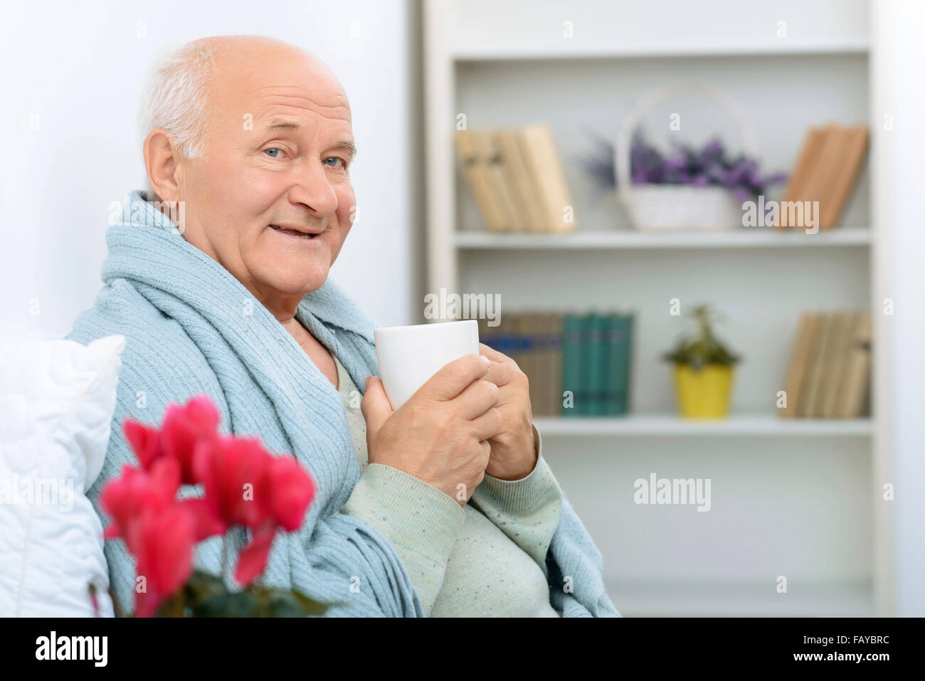 Älterer Herr grinst während glücklich ruhen. Stockfoto