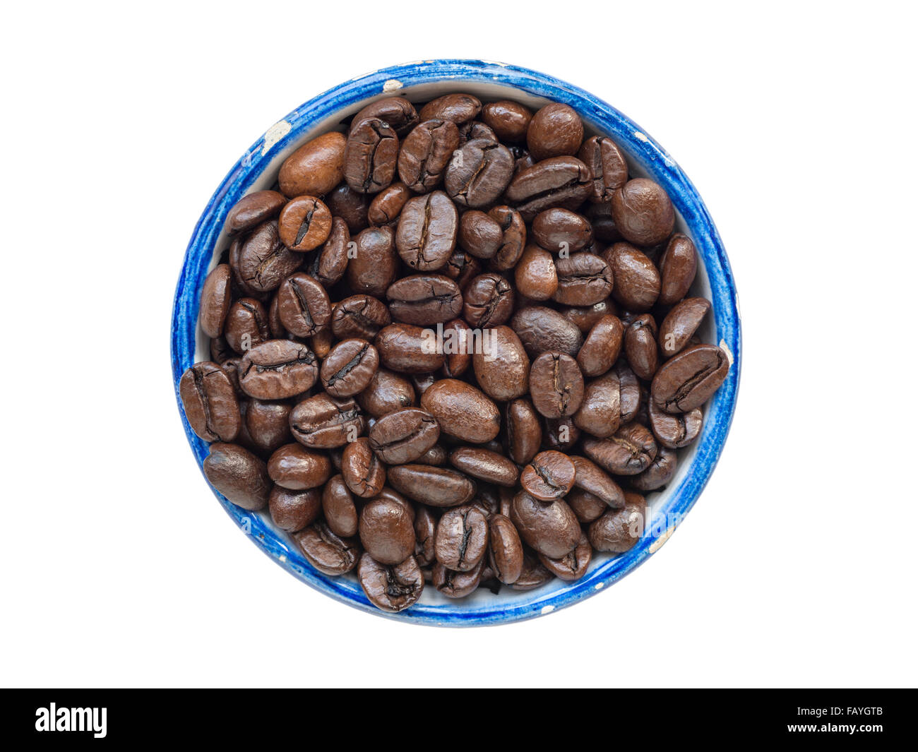 viele ganze geröstete Kaffeebohnen in runden blauen Tasse isoliert auf weiss Stockfoto