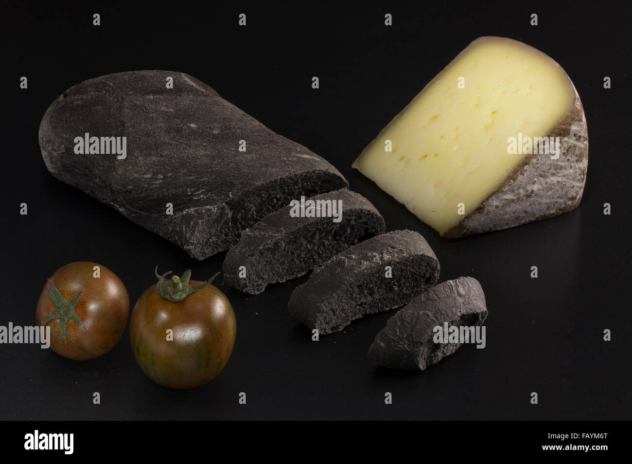 Schwarzes Brot mit pflanzlichen Carbon, schwarze Tomaten und Käse Stockfoto