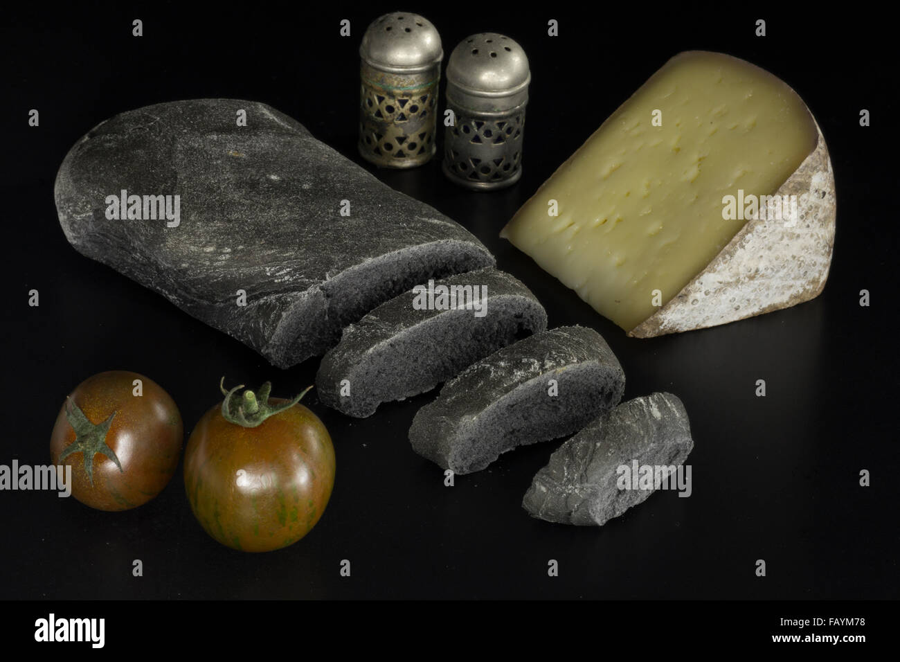 Schwarzes Brot mit pflanzlichen Carbon, schwarze Tomaten und Käse Stockfoto